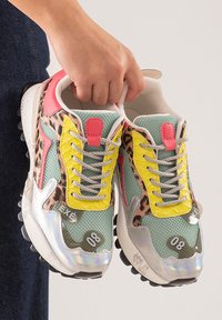 Zapatillas coloridas con una mezcla de malla verde menta, acentos de estampado de leopardo, detalles en amarillo y rosa, y elementos reflectantes en plata.