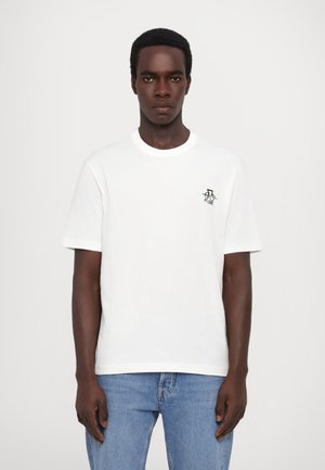 Hvit bomulls t-skjorte med korte ermer og rund hals, med en liten fargerik logo på brystet, sammen med lyseblå jeans.
