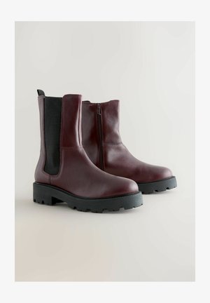 Bocanci de glezna din piele burgundă, cu fermoar lateral, panouri elastice negre contrastante și o talpă robustă din cauciuc negru pentru tracțiune.