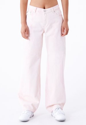 Vaqueros de pierna ancha de color rosa claro, hechos de denim, con una cintura alta, cierre de botones y un ligero desvanecimiento. Combinados con zapatillas blancas.