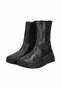 Botas de tobillo de cuero negro con una textura suave, paneles laterales elásticos y suelas de goma con detalles de agarre texturizado. Diseño de punta redondeada.