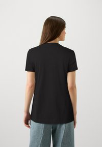 Zwarte t-shirt met korte mouwen en een ronde halslijn, van achteren getoond. De stof lijkt zacht en glad, met een losse pasvorm.