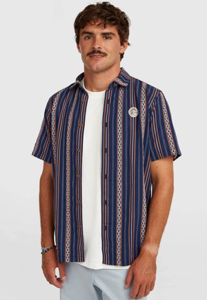 Kortærmet skjorte i marineblå med lodrette striber i orange og hvid. Har en knappet front og et rundt logopatch på brystet.