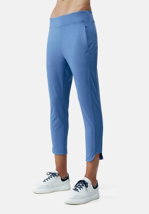 Blå atletiske capri-bukser med en glat tekstur, elastisk talje, og sidelommer, parret med hvide sneakers og marineblå accenter.