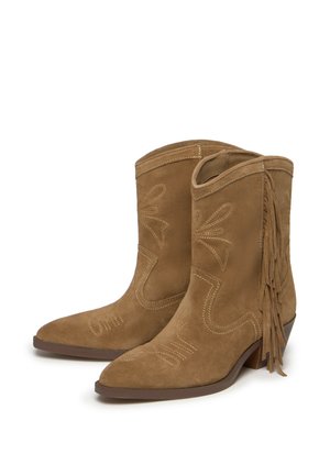 Botines de ante marrón con detalle de flecos y costuras bordadas. Punta afilada, tacón bajo apilado y recortes decorativos en los laterales.