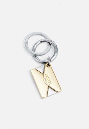 Silver double keyrings with a gold and silver geometric enamel charm engraved with "LANCEL PARIS" on a white background.