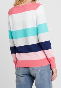 Flerfärgad randig tröja med rosa, blå, grå och marinblå ränder; ribbade ärmslut och nederkant; mjuk stickad textur; avslappnad design.