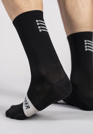Chaussettes de sport noires avec un design texturé, présentant un logo blanc sur le haut et une semelle à motifs pour une meilleure adhérence.