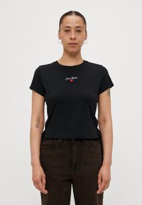 Zwarte katoenen t-shirt met korte mouwen, ronde hals, voorzien van geborduurde witte en rode tekst "Ciao Bella" en een klein rood hartdetail.