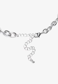 Collier en chaîne en argent avec un fermoir à pince. Il comporte des maillons ovales et une courte chaîne réglable se terminant par un petit détail en forme de boule.
