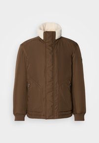 Brun isoleret jakke med høj krave, blød cremefarvet foring, ribbede manchetter og to sidelommer. Glat tekstur og moderne design.