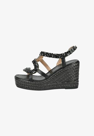 Sort kile-sandal med flettet platformsål, dekoreret med sorte og sølvfarvede perler på stropperne og med åben tå-design.