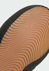 Czarna sportowa podeszwa z teksturowanej gumy, z falistymi rowkami i kontrastując�ą jasnobrązową śródpodeszwą.