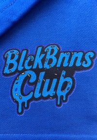Koninklijk blauwe stof bevat een logo in gemengde kleuren met "BlckBnn$ Club" in gestileerde letters, verfraaid met kleurrijke sprinkles en een druppelend effect.