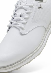 Scarpa in pelle bianca con punta rotonda, design con lacci, dettagli perforati, accenti grigio chiaro e suola bianca a contrasto. Logo argentato sul lato.