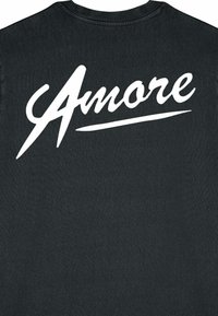 Juodas marškinėlis su dideliu baltu užrašu "Amore" švelniu šriftu ant nugaros. Minkšta, tekstūruota medžiaga su apvaliu iškirpimu.