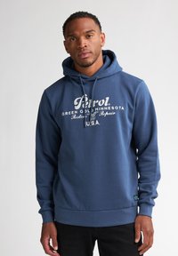 Felpa con cappuccio blu navy realizzata in tessuto morbido, con stampa grafica frontale in bianco. Include un cappuccio con cordino e polsini e fondo a costine.