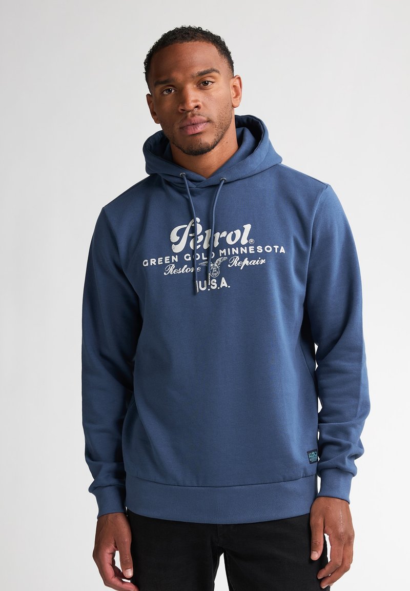 Felpa con cappuccio blu navy realizzata in tessuto morbido, con stampa grafica frontale in bianco. Include un cappuccio con cordino e polsini e fondo a costine.