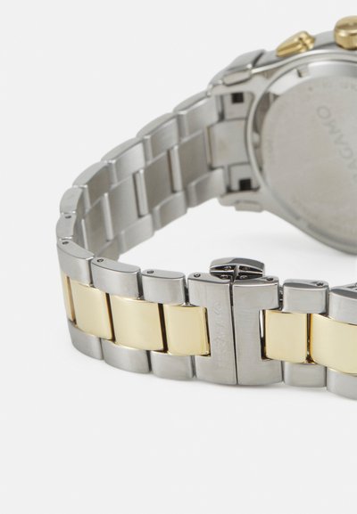 Silver and gold-tone metal watch band with a polished finish. Features alternating silver links and gold accents, secure clasp detail visible.