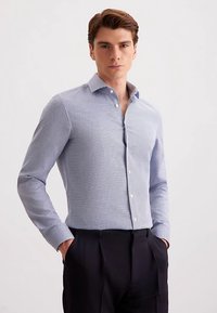 Blauw-wit geruit shirt met lange mouwen, een button-downkraag en een getailleerd ontwerp. Glad stof met een subtiele textuur.