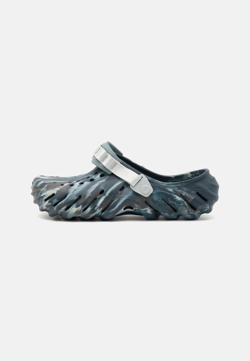 Clog with a wavy design in dark blue and grey, made of lightweight material. Features a silver adjustable strap and ventilation holes.