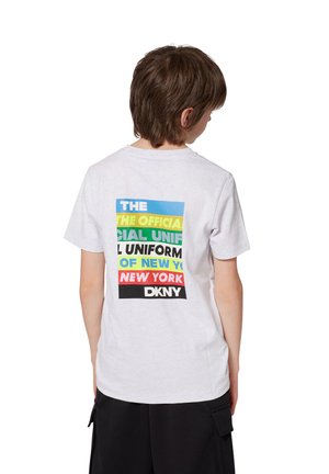 T-shirt en coton blanc à manches courtes, avec un design graphique multicolore au dos, affichant le texte et le logo de DKNY.