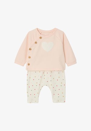 Weiches rosa Babyoberteil mit langen Ärmeln, Holzknöpfen und weißem Herz, kombiniert mit weißen Hosen, die mit kleinen mehrfarbigen Herzen verziert sind.