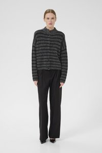 Dark gray and black striped knit cardigan with a high collar and button closure, featuring a loose fit and long sleeves. Paired with black trousers.