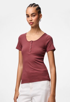 Short-sleeve, ribbed top in dusty rose with a scoop neckline and five button details at the front. Made of stretchy fabric for comfort.
