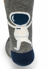 Calzino grigio con punta blu navy raffigurante un personaggio astronauta bianco con un casco blu scuro e le braccia sollevate.