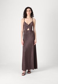 Rochie maxi de culoare șampanie, cu un design cu torsadare în față, detaliu tip cheie, bretele subțiri și o textură netedă, strălucitoare.