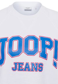 Witte sweatshirt met grote blauw en rood omrande tekst "JOOP!" bovenop de kleinere tekst "JEANS" op de borst, met zichtbare kraag en label in de nek.