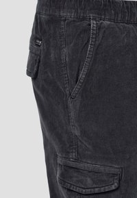 Pantalons cargo en velours côtelé noir avec poches latérales et finition texturée, dotés d'une taille à cordon de serrage pour un ajustement réglable.