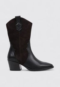 Botas de cowboy de cuero negro y ante marrón oscuro con punta afilada, parte superior con ondas y tacón apilado, con costuras decorativas.