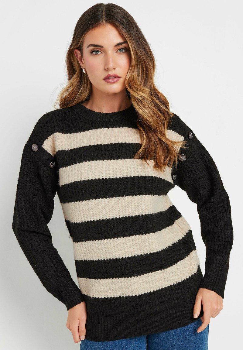 Maglione a righe nere e crema con texture a coste, scollatura rotonda e dettagli con bottoni sulle maniche. Maniche lunghe e vestibilità comoda.