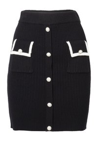 Jupe en maille côtelée noire avec des accents blancs, deux poches avant et des boutons en forme de perles ronds au centre pour la fermeture.
