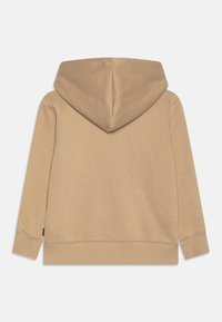 Sudadera beige con una capucha grande, mangas largas y puños acanalados. Textura suave, diseño minimalista y sin patrones ni elementos metálicos visibles.