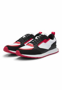 Black, white, and red sneakers feature a sporty design, textured fabric, cushioned sole, and a reinforced heel with a pull tab.