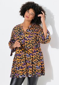 Multikleurige verhoogde jurk met een oranje, zwarte en paarse dierenprint, met een V-hals en driekwart mouwen.