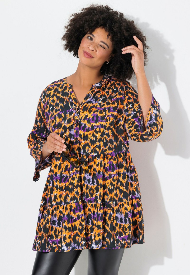 Multikleurige verhoogde jurk met een oranje, zwarte en paarse dierenprint, met een V-hals en driekwart mouwen.