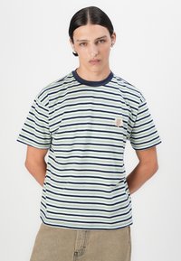 Stribet t-shirt med horisontale grønne, marineblå og hvide striber, en kontrast marineblå halsudskæring og et lille broderet logo på brystet.