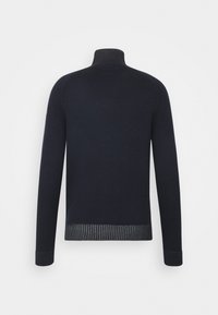 Pull en maille bleu marine avec un col haut, des manches longues, un ourlet côtelé et des accents texturés aux poignets et à la taille. Finition lisse sur l'ensemble.