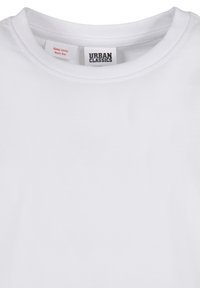 Weißes T-Shirt mit Rundhalsausschnitt und sichtbaren inneren Etiketten, darunter eines mit der Aufschrift "URBAN CLASSICS" und einem kleineren roten Textetikett mit der Aufschrift "Keep away from fire."