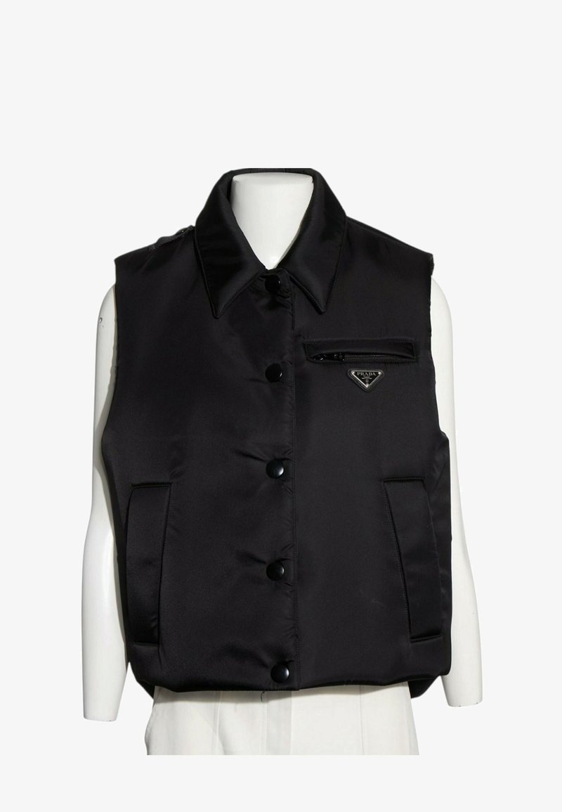 Veste matelassée noire sans manches avec col, boutons devant, deux poches latérales et petite poche zippée avec logo Prada sur la poitrine.
