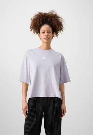 Una camiseta de manga corta en color lila con cuello redondo y un logo blanco en el pecho. Combinada con pantalones negros de rayas. Material de algodón suave.
