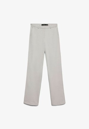 Heledast hallid, laia säärega püksid siledast, tekstuurse kangaga. Esiküljel taskud ja vöökoht koos tugevduslõngaga kinnitamiseks.