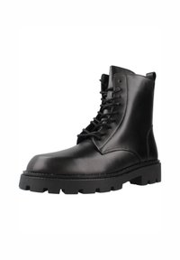 Botas de tobillo de cuero negro con puntera redonda, cordones en la parte delantera y suela de goma gruesa con profundas ranuras para tracción. Acabado suave y costuras mínimas.
