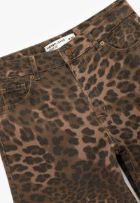 Jeans larghi in tessuto a stampa leopardata marrone e beige, con design a cinque tasche, chiusura con bottone e dettagli di cucitura a contrasto.