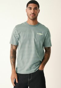Kurzärmliges T-Shirt mit Rundhalsausschnitt in Salbeigrün mit weißen horizontalen Streifen. Verfügt über ein kleines Logo auf der linken Brustseite. Der Stoff wirkt weich.