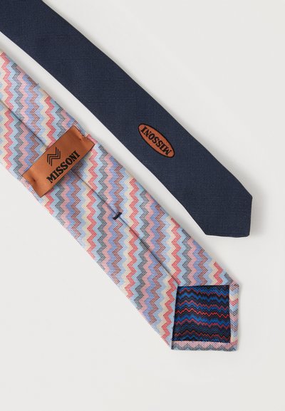 Deux cravates Missoni, une bleu marine en tissu texturé avec logo en cuir, une autre à motif zigzag multicolore avec logo en cuir et extrémité intérieure contrastée.